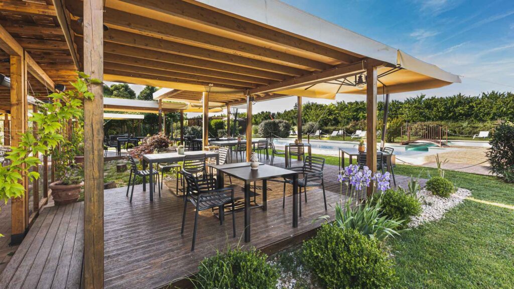 Giardino estivo della Favorita, ritrae il dehor esterno circondato da fiori con vista piscina