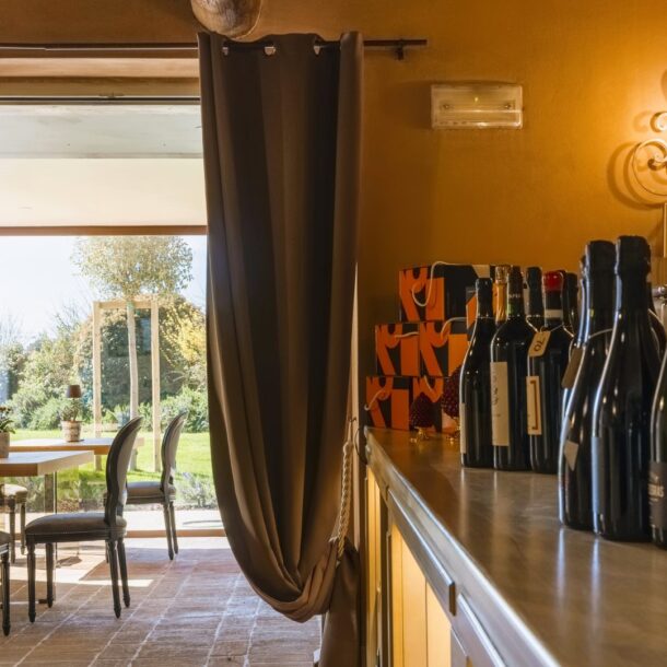 Interno Osteria Favorita con bottiglie di Champagne e vista sul giardino
