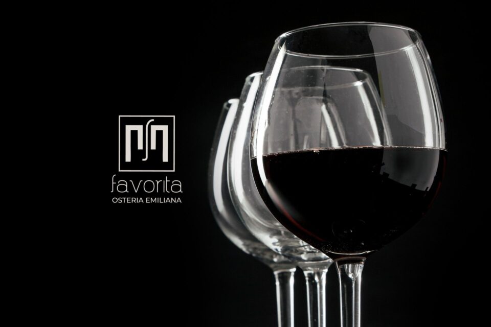 Calici di vino rosso su sfondo nero con logo Osteria Favorita – immagine simbolo della serata Vini Veri 2026