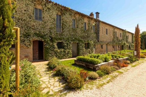 Facciata dell’Osteria Favorita a Bastia Umbra immersa nel verde primaverile, aperture straordinarie primavera 2026