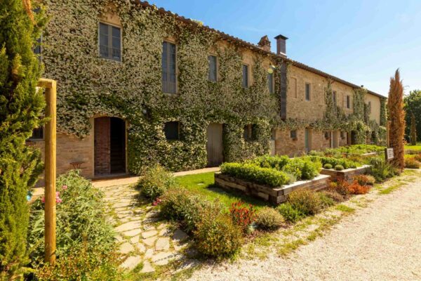 Facciata dell’Osteria Favorita a Bastia Umbra immersa nel verde primaverile, aperture straordinarie primavera 2026